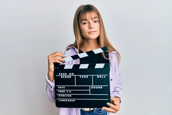 Nastolatka Rasy Kaukaskiej Trzymająca Kasetę Wideo Klapką Zrelaksowana Poważnym Wyrazem — Zdjęcie stockowe