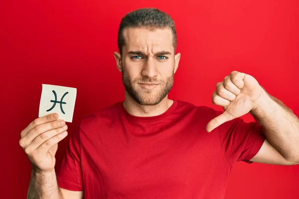 Young Caucasian Man Holding Paper Pisces Zodiac Sign Angry Face — Fotografia de Stock