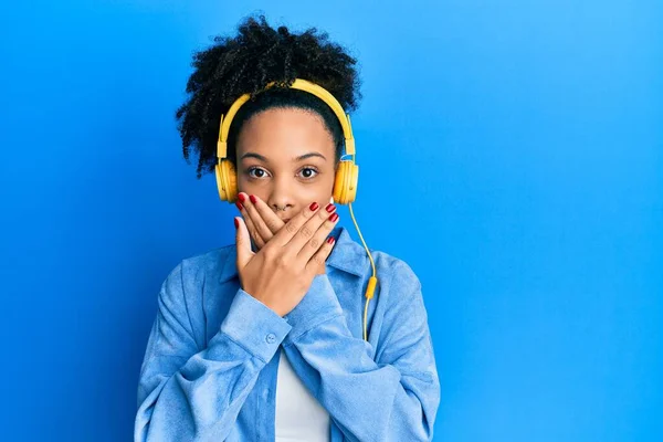 Chica Afroamericana Joven Escuchando Música Usando Auriculares Impactados Cubriendo Boca —  Fotos de Stock