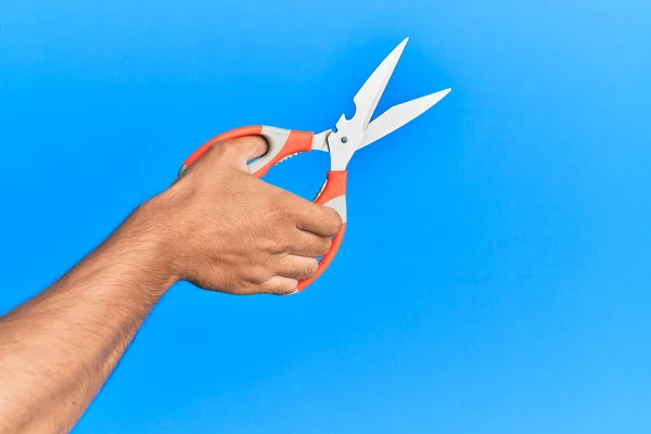 Mano Joven Hispano Usando Tijeras Sobre Fondo Azul Aislado — Foto de Stock