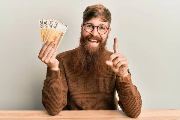 Young Irish Redhead Man Holding 500 Norwegian Krone Banknotes Sitting — Stockfoto