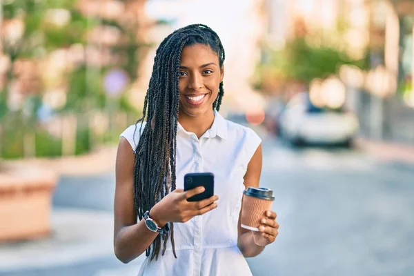 アフリカ系アメリカ人の若い女性がスマートフォンでコーヒーを飲みながら — ストック写真