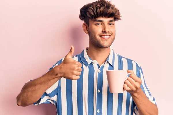 Joven Hombre Hispano Sosteniendo Café Sonriendo Feliz Positivo Pulgar Hacia — Foto de Stock