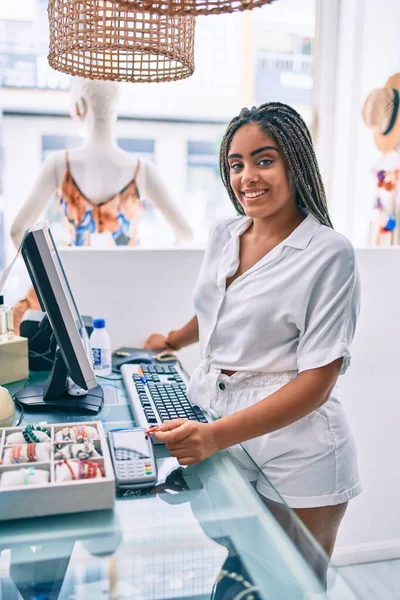 年轻的非洲裔美国女人开心地笑着在零售店的柜台边干活 — 图库照片