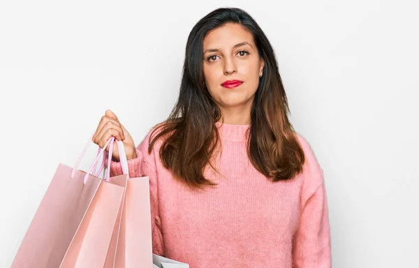 Schöne Hispanische Frau Mit Einkaufstaschen Denkender Haltung Und Nüchternem Ausdruck — Stockfoto