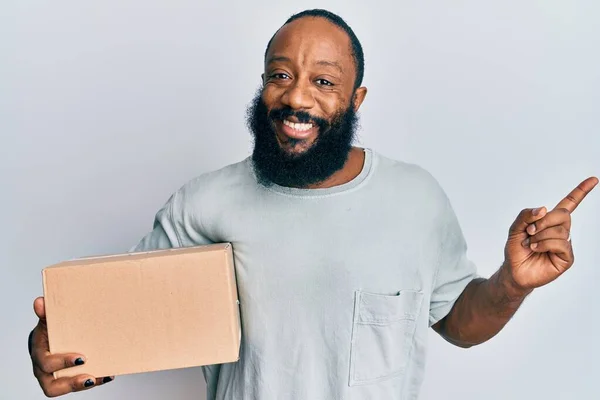 Joven Afroamericano Hombre Sosteniendo Paquete Entrega Sonriendo Feliz Señalando Con — Foto de Stock