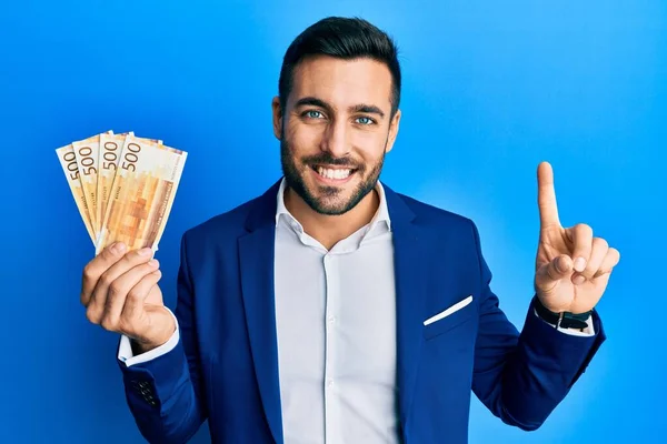 Joven Empresario Hispano Con Traje Negocios Sosteniendo Billetes Noruegos Sonriendo —  Fotos de Stock