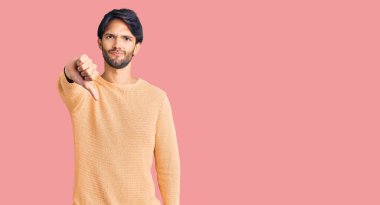 Yakışıklı, sıradan süveter giyen, mutsuz görünen, reddedilmiş ve olumsuz davranan yakışıklı bir adam. kötü ifade. 