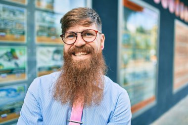 Uzun sakallı, genç, kızıl saçlı işadamı şehire doğru mutlu adımlarla yürüyordu..