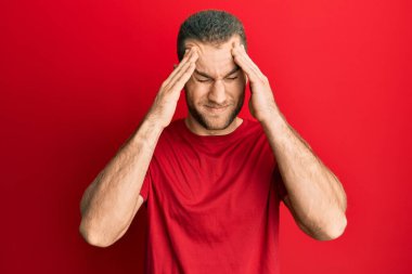 Kafkasyalı genç bir adam elleri kafasında günlük kıyafetler giyiyor, stres yüzünden baş ağrısı çekiyor. migren ağrısı. 