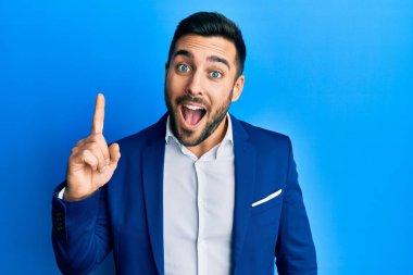 Genç İspanyol iş adamı iş ceketi giyiyor ve başarılı bir fikir sunuyor. Heyecanlı ve mutlu. Bir numara.. 