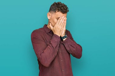 Ağlarken suratını ellerle kapatan, günlük kıyafetler giyen genç İspanyol. depresyon kavramı. 