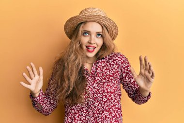 Sarışın, beyaz, yaz şapkalı güzel bir kadın. Deli gibi bağırıyor, agresif bir ifadeyle bağırıyor ve kollarını kaldırıyor. hüsran kavramı. 