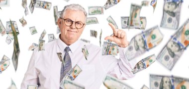 İş kıyafetleri giymiş, gülümseyen, kendine güvenen, el hareketi yapan, parmaklarıyla işaret yapan, kameraya bakan yaşlı gri saçlı bir adam. ölçüm kavramı.