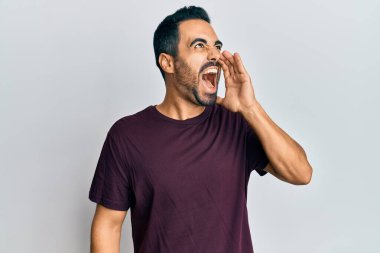 Latin asıllı genç adam günlük kıyafetler giyip el ele tutuşarak bağırıyor ve çığlık atıyordu. iletişim konsepti. 