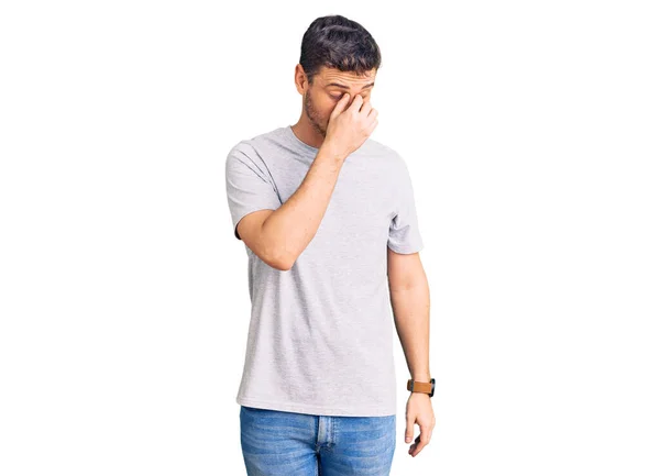 カジュアルなTシャツを着てクマのハンサムな若い男は 鼻と目をこすり疲れや頭痛を感じて疲れている ストレスとフラストレーションの概念 — ストック写真