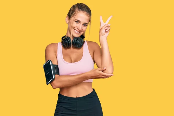 Mujer Rubia Joven Usando Ropa Gimnasio Usando Auriculares Sonriendo Con —  Fotos de Stock