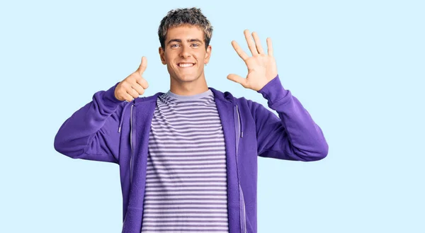 年轻英俊的男子穿着休闲的紫色运动衫 手指头指了指六号 面带微笑 自信而快乐 — 图库照片