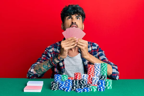 Jovem Hispânico Jogando Poker Cobrindo Rosto Com Cartas Com Raiva — Fotografia de Stock