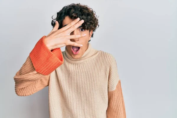 Latynoski Młodzieniec Noszący Luźny Zimowy Sweter Podglądający Dłońmi Twarz Oczy — Zdjęcie stockowe