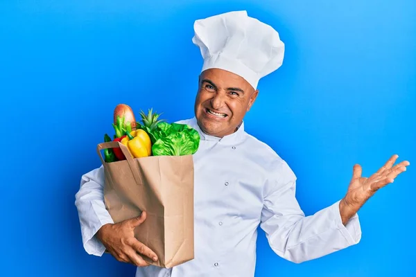 Mature Middle East Man Professional Chef Holding Bag Groceries Celebrating — Stock Photo, Image