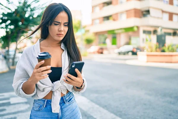 Joven Chica Hispana Con Expresión Seria Usando Smartphone Bebiendo Café — Foto de Stock