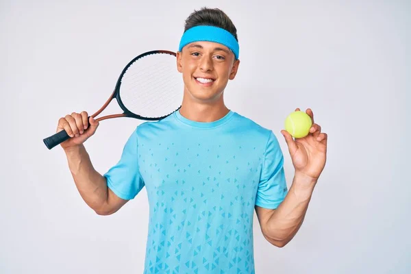 若いヒスパニック系の少年は 顔に幸せとクールな笑顔でラケットとボールの笑顔を保持テニスをプレイ 歯を見せて — ストック写真