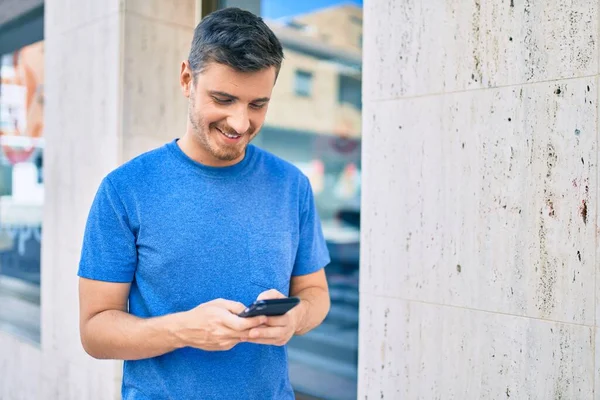 Mladý Kavkazský Muž Usměvavý Šťastný Pomocí Smartphonu Městě — Stock fotografie