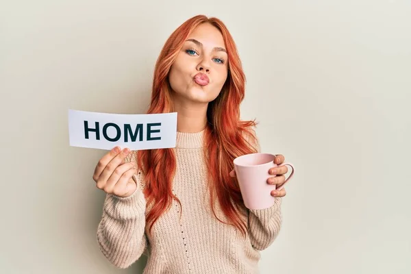 Jovem Ruiva Bebendo Uma Xícara Café Segurando Texto Casa Olhando — Fotografia de Stock