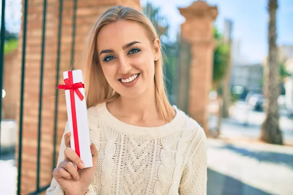 Jovem Loira Sorrindo Feliz Segurando Presente Cidade — Fotografia de Stock