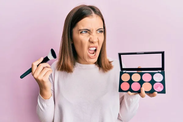 Young Beautiful Woman Holding Makeup Brush Blush Angry Mad Screaming — Foto de Stock