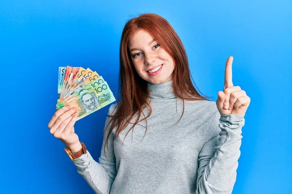 Joven Chica Pelirroja Sosteniendo Dólares Australianos Sonriendo Con Una Idea — Foto de Stock