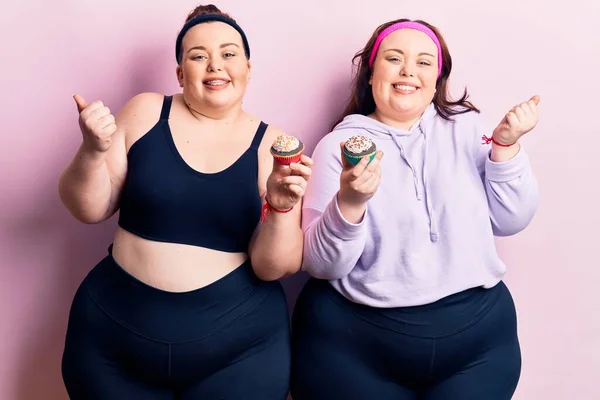 Young Size Twins Wearing Sportswear Holding Cupcake Screaming Proud Celebrating — Stock Photo, Image