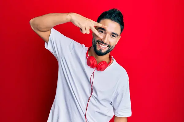 Joven Con Barba Escuchando Música Usando Auriculares Haciendo Símbolo Paz —  Fotos de Stock