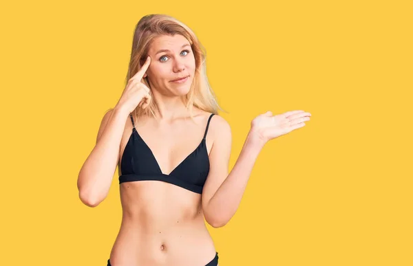 Fiatal Gyönyörű Szőke Bikinit Visel Összezavarodva Bosszankodva Nyitott Tenyérrel Mutatja — Stock Fotó