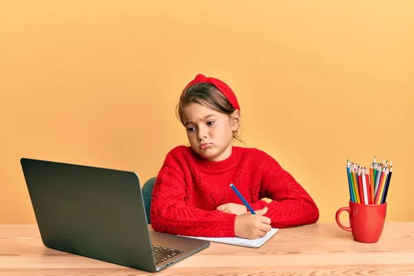 Little beautiful girl studying using computer laptop depressed and worry for distress, crying angry and afraid. sad expression.