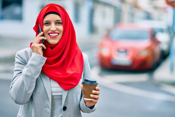 若いアラブ人実業家が市内のスマートフォンで話してコーヒーを飲む — ストック写真