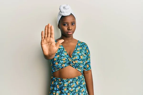 髪のターバンとアフリカスタイルを身に着けている若いアフリカの女性は 手の手のひらで歌うのを止めます 顔に負の重大なジェスチャーで — ストック写真