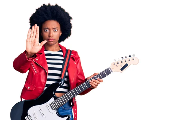 若いですアフリカ系アメリカ人女性遊びます電動ギターでオープン手を行います停止記号で深刻で自信を持って式 防衛ジェスチャー — ストック写真