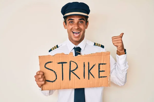 Young Hispanic Man Wearing Airplane Pilot Uniform Holding Strike Banner — Stock Photo, Image