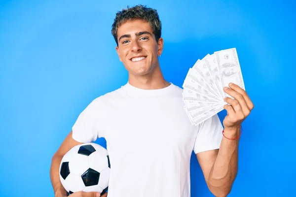 Joven Hombre Guapo Sosteniendo Pelota Fútbol Billetes Dólares Sonriendo Con —  Fotos de Stock