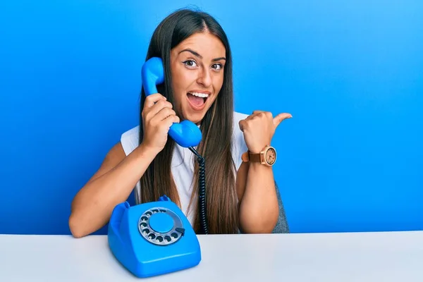 Beautiful Hispanic Woman Speaking Vintage Telephone Pointing Thumb Side Smiling — Stock Photo, Image