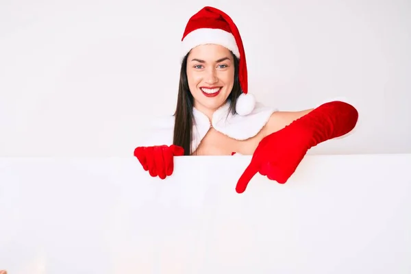 Young Woman Wearing Santa Claus Costume Holding Blank Empty Banner — Stock Photo, Image