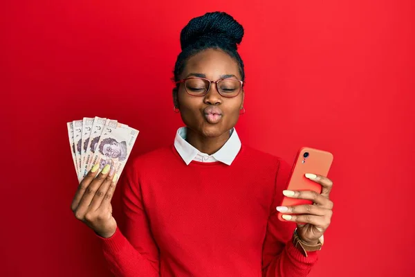 Joven Mujer Afroamericana Usando Smartphone Sosteniendo Billetes Peso Mexicano Mirando —  Fotos de Stock