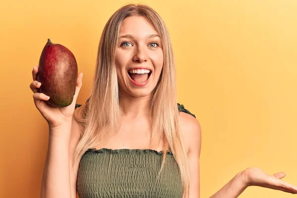 Genç Güzel Sarışın Kız Mango Tutuyor Başarıyı Mutlu Bir Gülümsemeyle — Stok fotoğraf