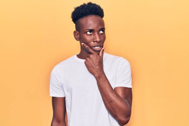 Gündelik giysiler giyen genç Afro-Amerikan bir soru hakkında endişeli ve gergin bir şekilde düşünüyor. 