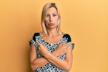 Orta yaşlı, beyaz bir kadın farklı yönleri işaret ediyor. Depresyonda ve endişe içinde, sinirli ve korkmuş. hüzünlü ifade. 