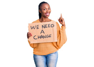 Elinde bir değişiklik pankartı tutan Afrikalı genç bir kadın. Bir fikir ya da soru işareti ile şaşırmış, mutlu yüzlü, bir numara. 