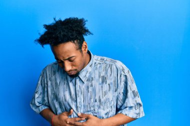 Sakallı, elleri karnında günlük kıyafetler giyen Afro-Amerikalı genç bir adam. Çünkü hazımsızlık, acı verici bir hastalık ve kendini iyi hissetmiyor. Ağrı kavramı. 