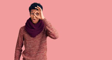 Sıradan bir kazak ve eşarp giyen Afro-Amerikan genç adam şaşırmış yüz ifadesiyle şaşırmış, parmaklarından bakan bir jest yapıyor. İnançsız ifade. 